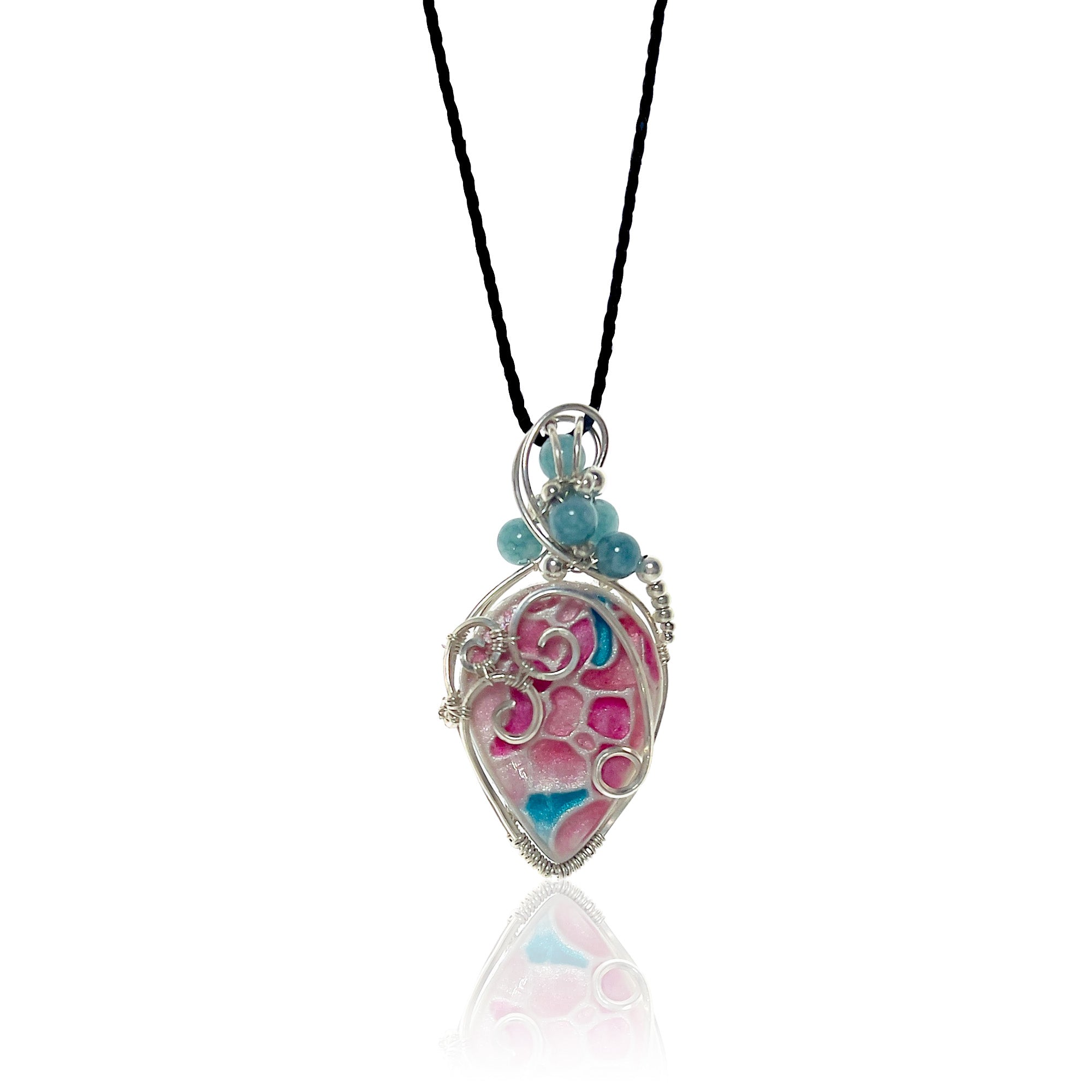 Drop-shaped pendant with an original hand crafted and hand-painted stone with pinks, and turquoises and sterling silver scrollwork, serpentine aquamarine beads with silver and glass beads at the top, hung from a silk cord.