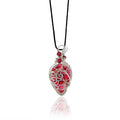 Drop-shaped pendant hand painted with rich reds accented with peach and sterling silver scrollwork, red riverstone beads with silver and glass beads at the top, hung from a silk cord.