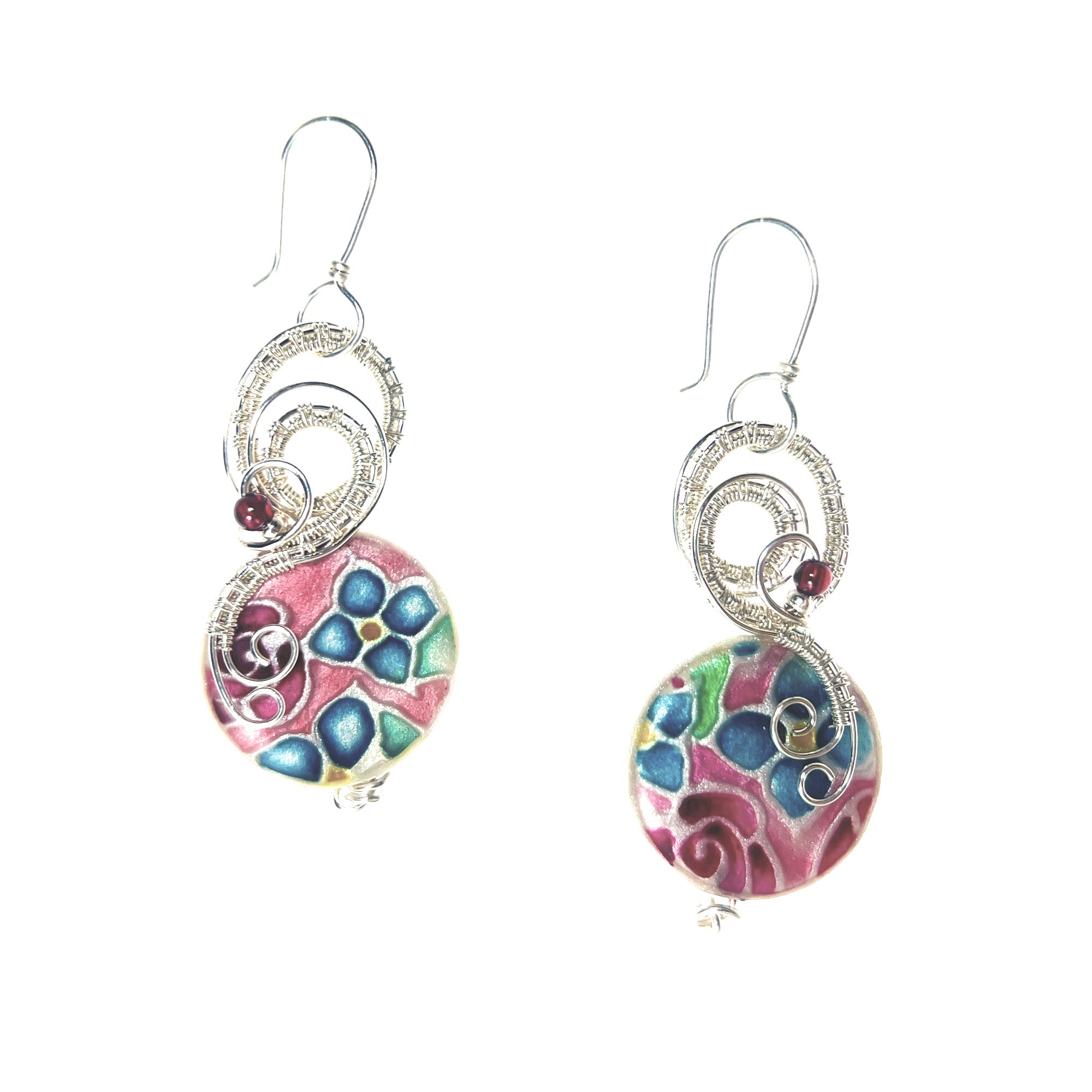 A pair of dangle earrings featuring magenta beads and a pink, teal blue, magenta and green floral pattern, suspended from sterling silver hooks.