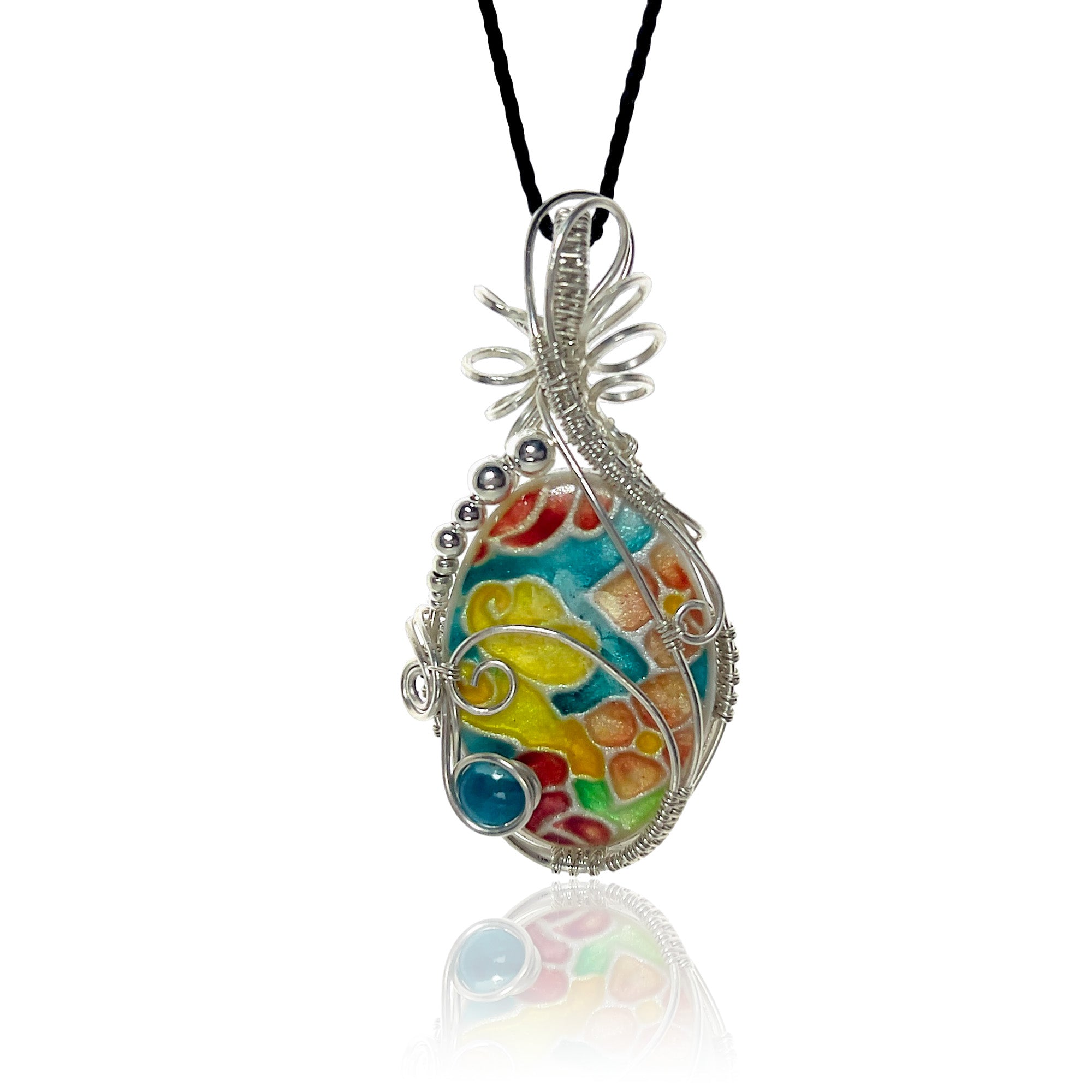 Sterling silver scrollwork pendant necklace with a hand-painted floral design in turquoise, red and gold, hung from a black silk cord.