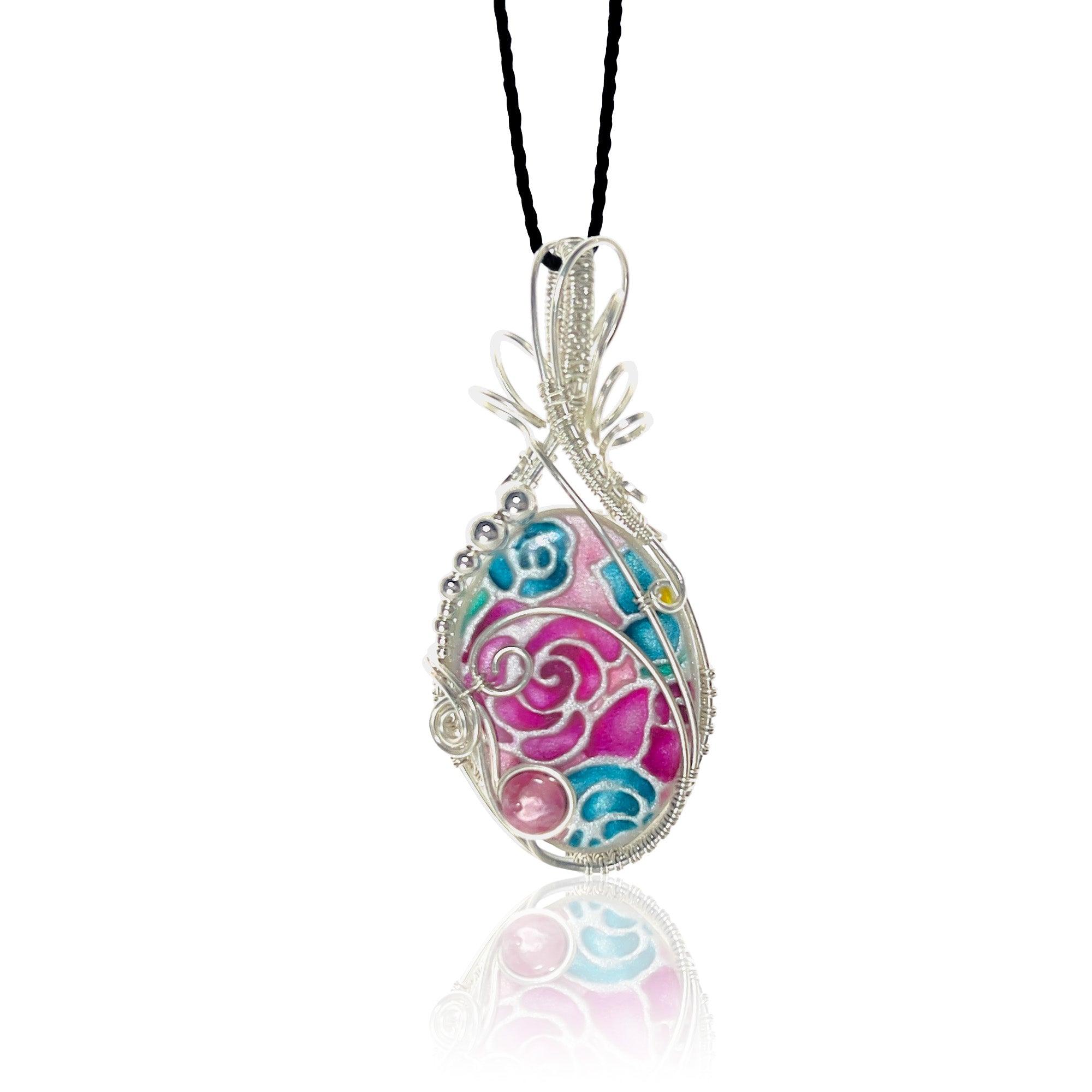 Sterling silver scrollwork pendant necklace with a hand-painted floral design in pink, blue, and teal floral patterns, hung from a black silk cord.