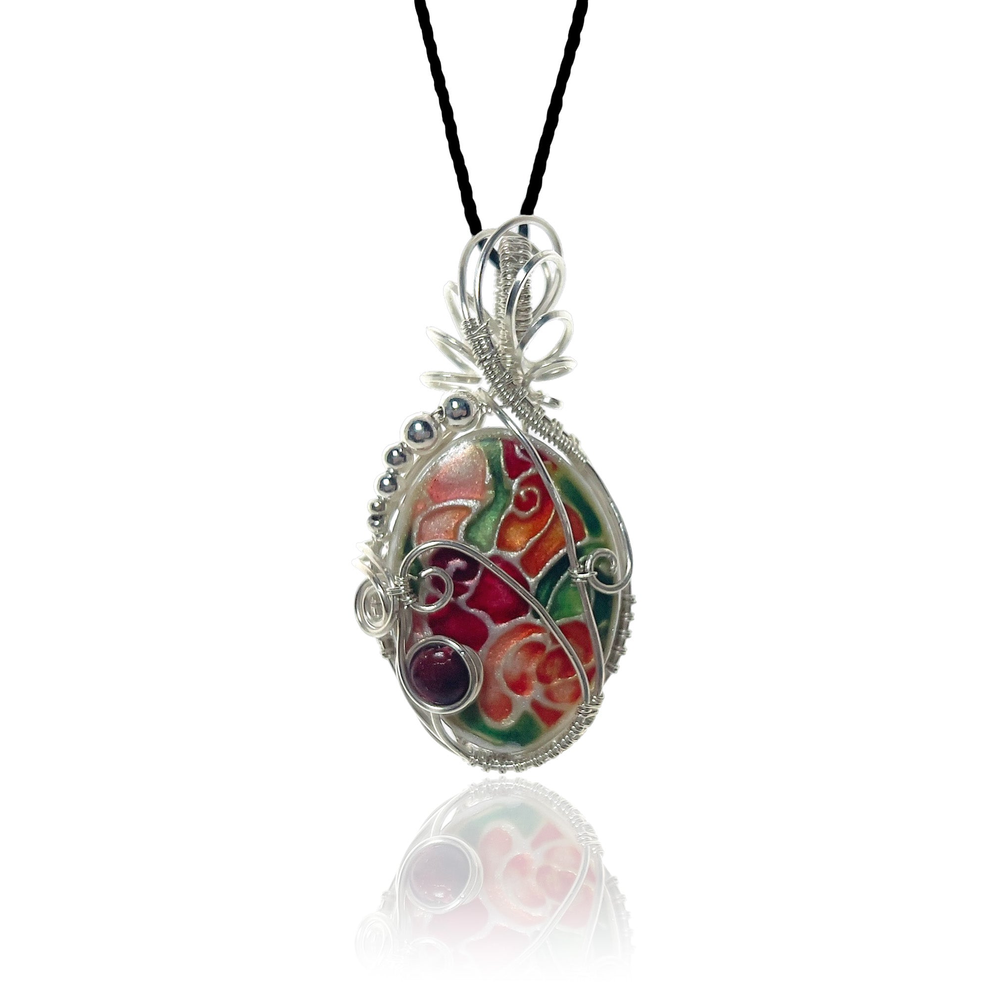 Sterling silver scrollwork pendant necklace with a hand-painted floral design in red, green, and purple, hung from a black cord.