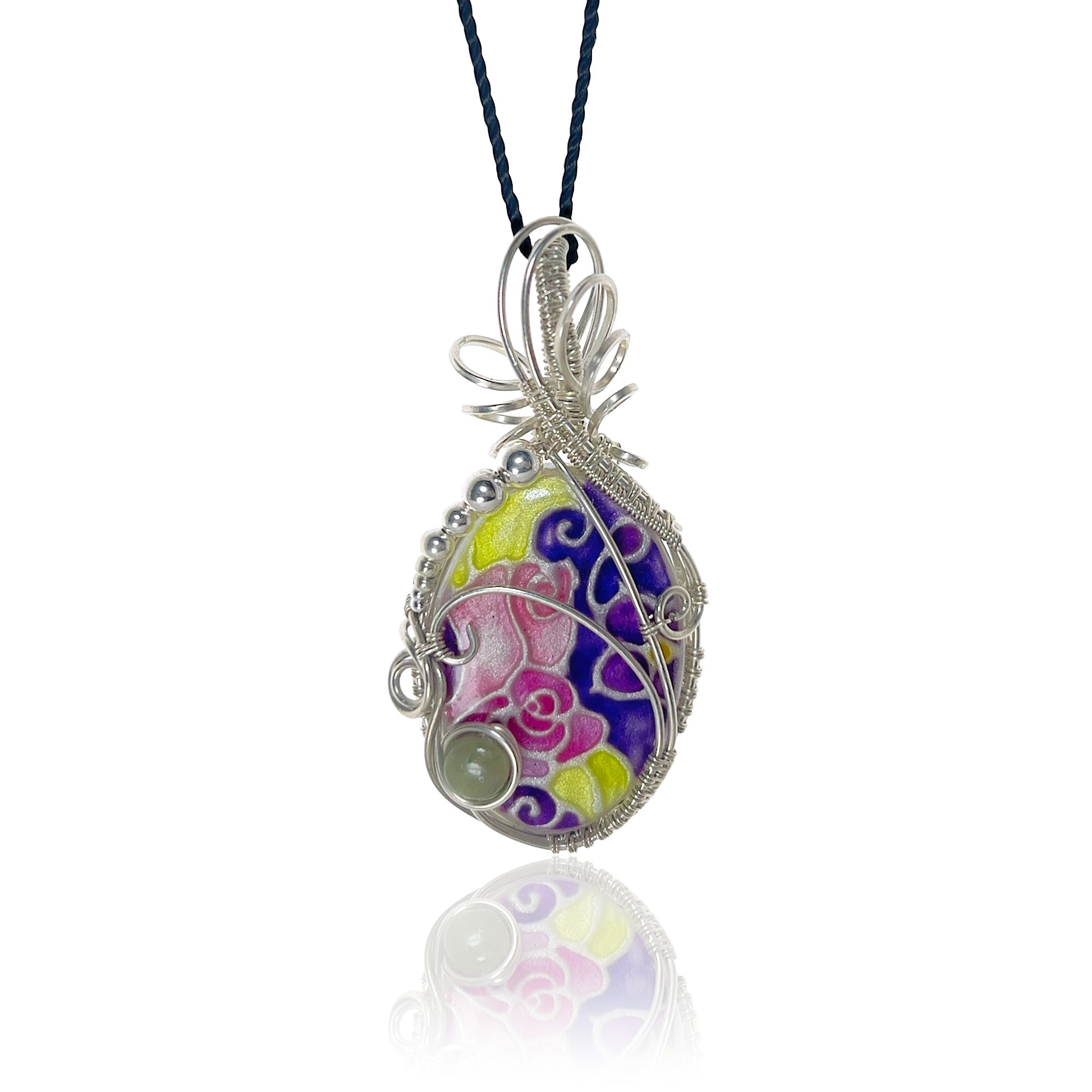 Sterling silver pendant necklace with a hand-painted floral and swirl design in purple, pink, yellow, and green, hung from a black silk cord.