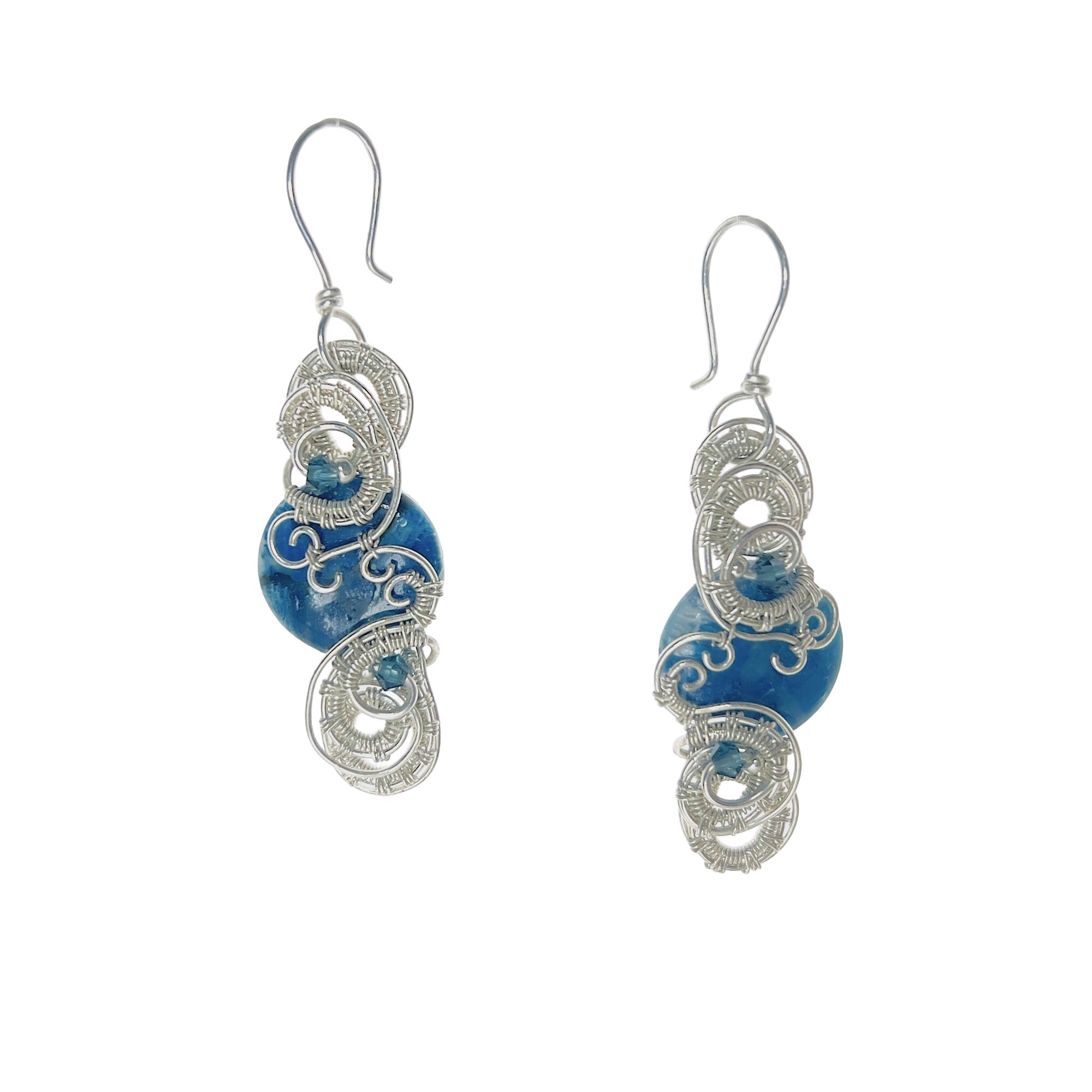 Round earrings featuring a blue stone with continuous interlaced sterling silver details framing its top and bottom, accented by two blue Austrian crystals.