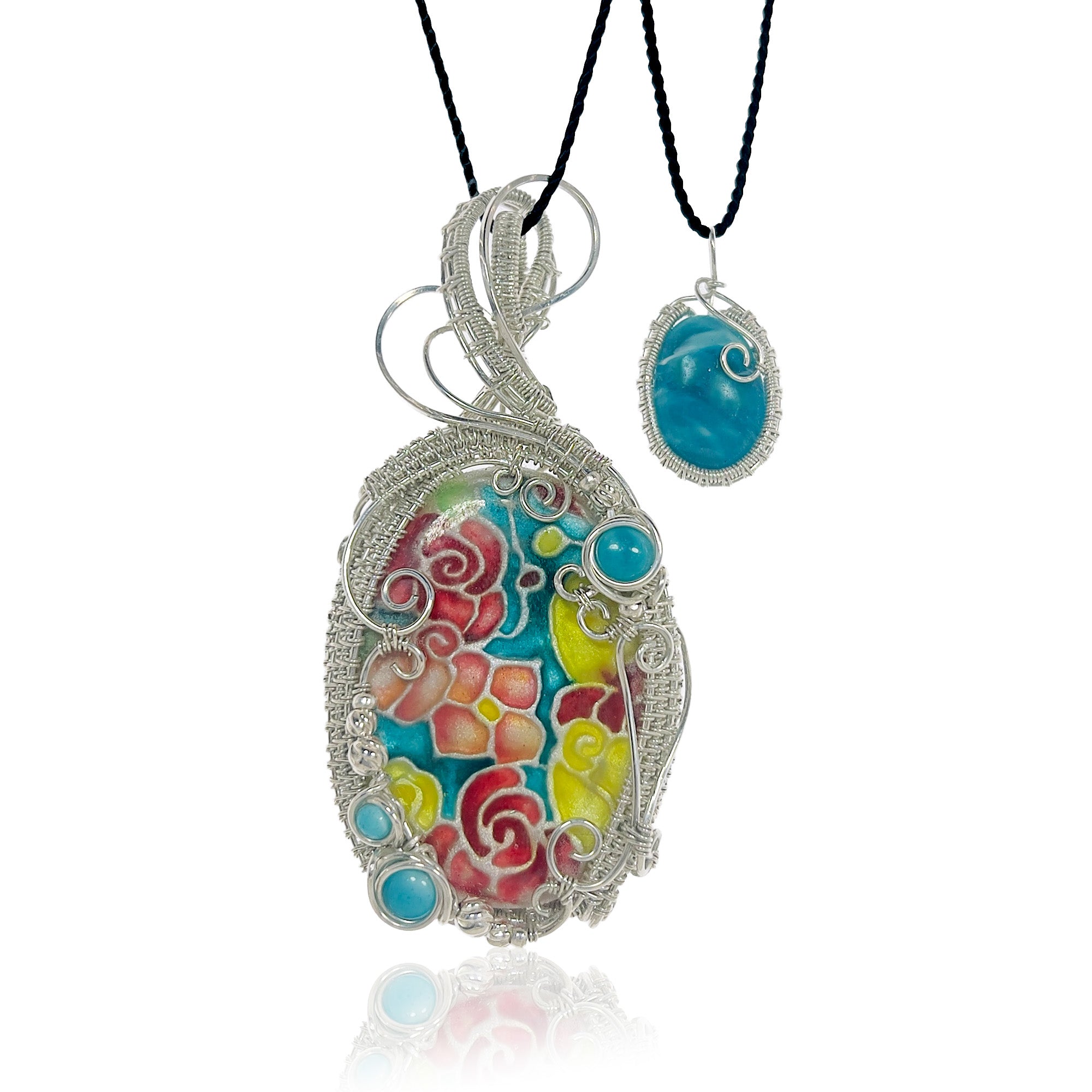 Turquoise pendant set with yellow, red, and auburn hand-painted floral design, inspired by Kingman turquoise, with three matching beads wrapped in sterling silver. Elaborate sterling silver work frames the pendant, with woven wire framing the small statement piece.